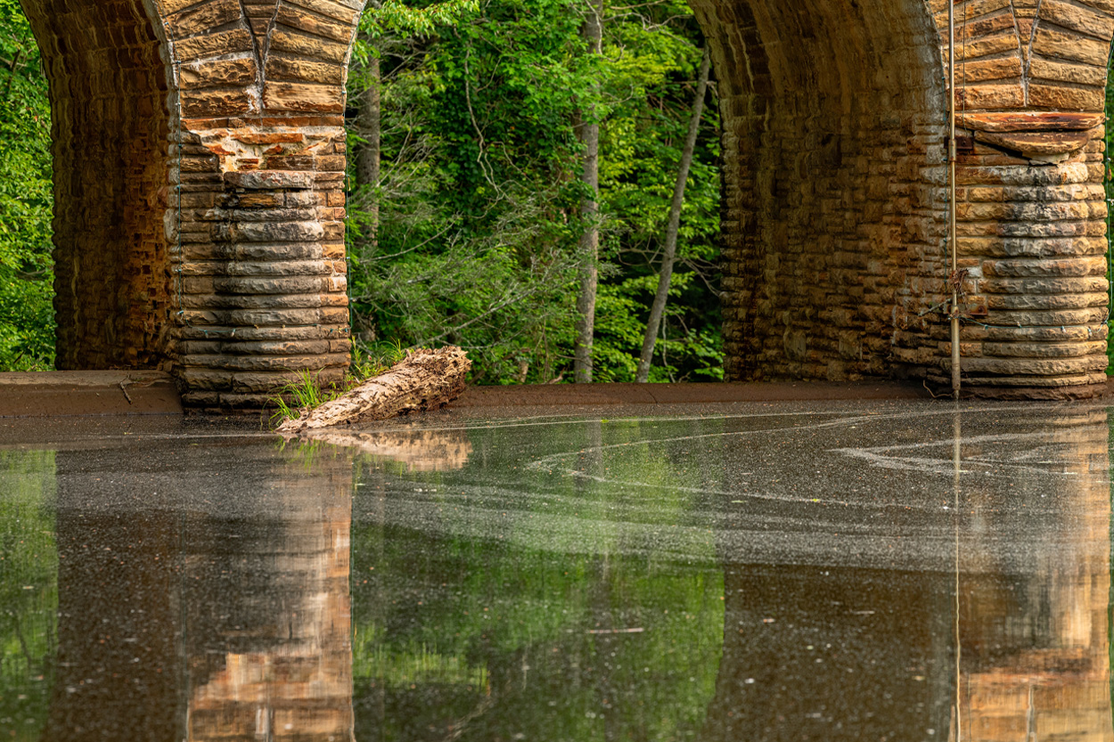 Stone arch bridge reflected in calm water near Crab Orchard, Tennessee