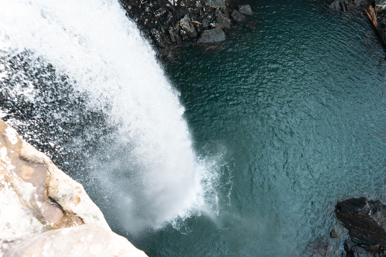 Waterfall plunging into a clear blue pool in Cumberland Cove, Tennessee