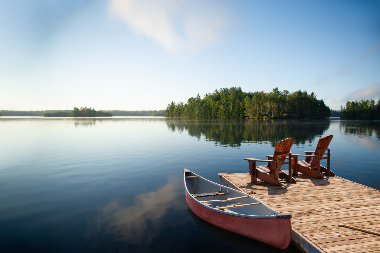 Canoe and Adirondack chairs on a dock overlooking calm water near Farragut, Tennessee