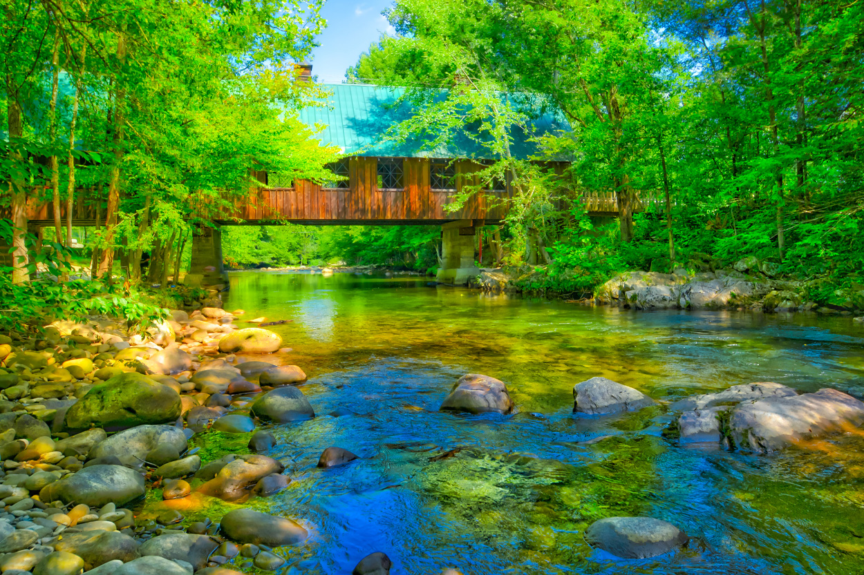 Clear mountain stream flowing beneath a covered bridge near Gatlinburg, Tennessee