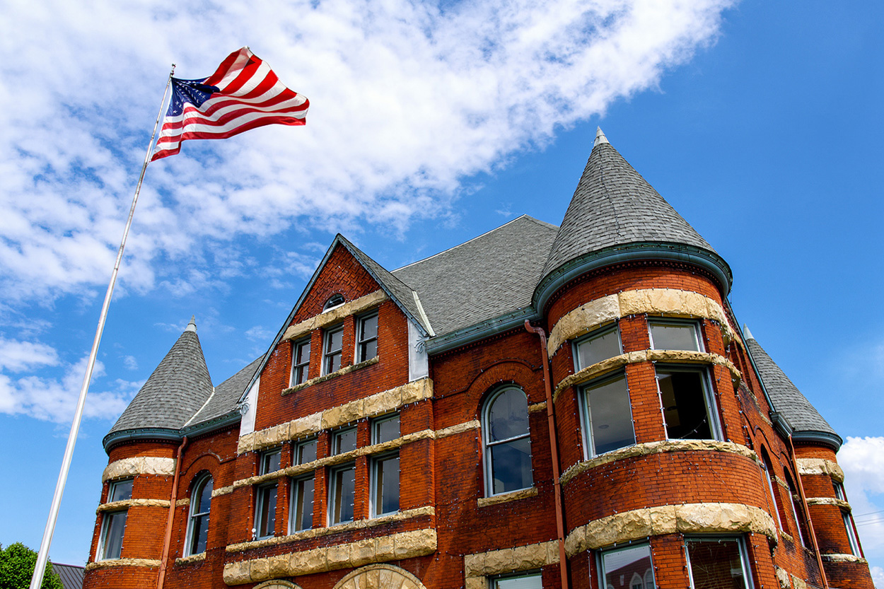 Historic red-brick building with a turret and American flag in Harriman, Tennessee
