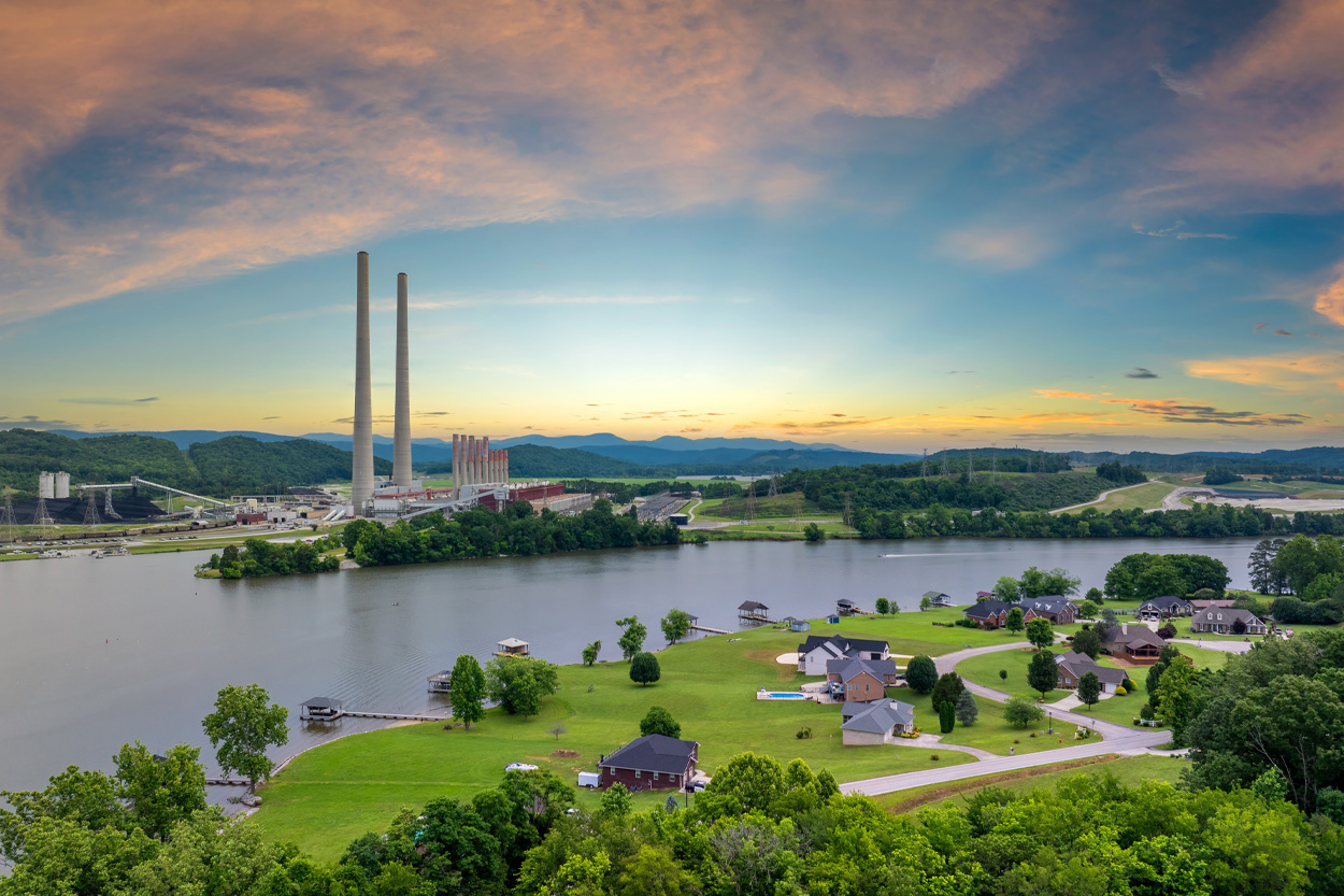 Waterfront community and industrial skyline at sunset representing Kingsport, Tennessee