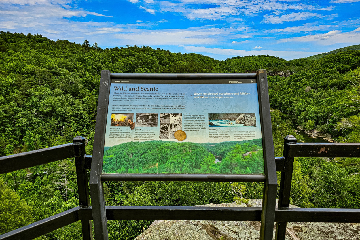 Scenic overlook and interpretive sign surrounded by forested hills near Lancing, Tennessee
