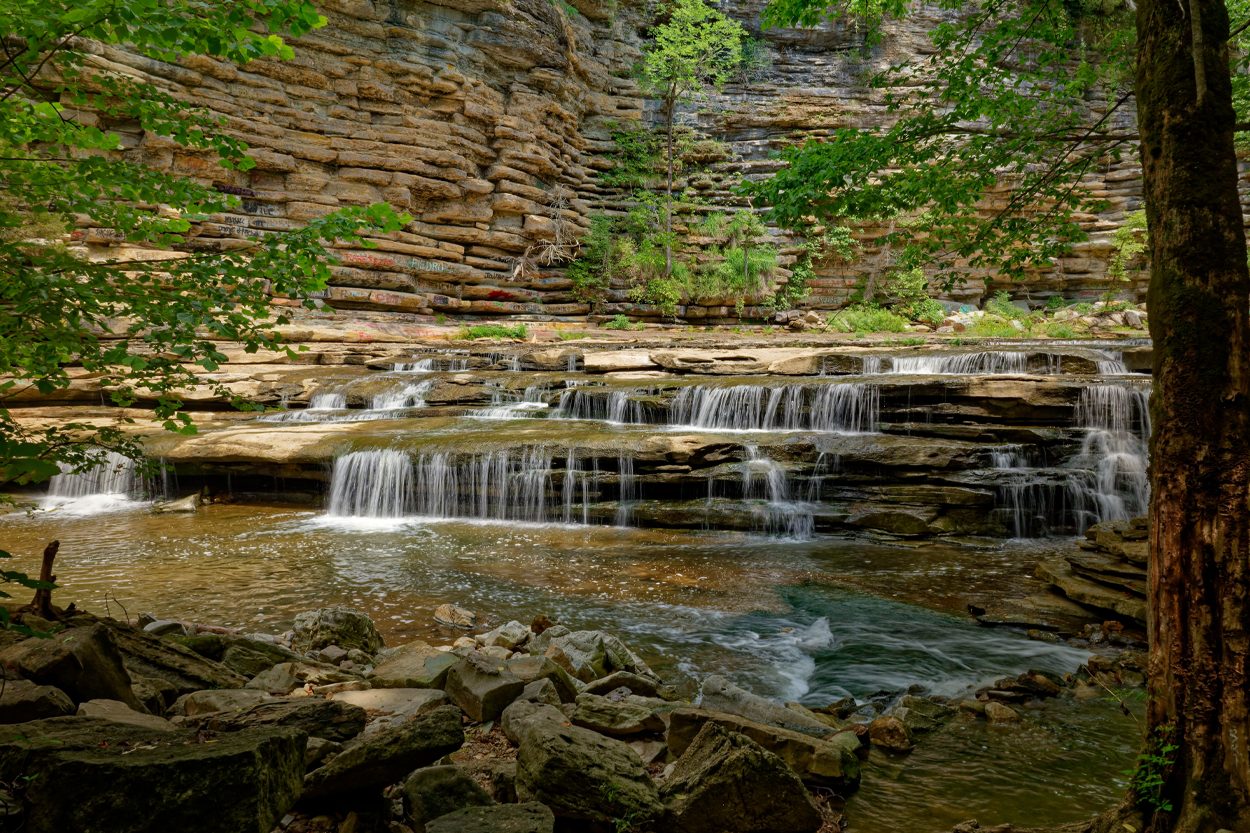 Layered rock waterfall flowing through a wooded mountain setting near Walland, Tennessee