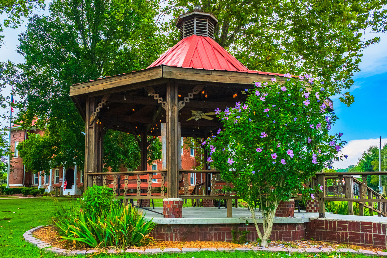 Landscaped wooden gazebo with a red roof in Wartburg, Tennessee