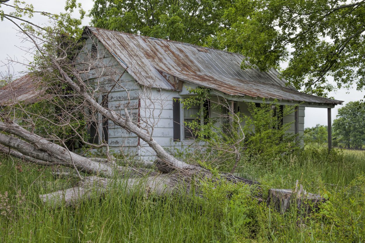 Weathered rural cabin surrounded by trees near Madisonville in Monroe County, Tennessee