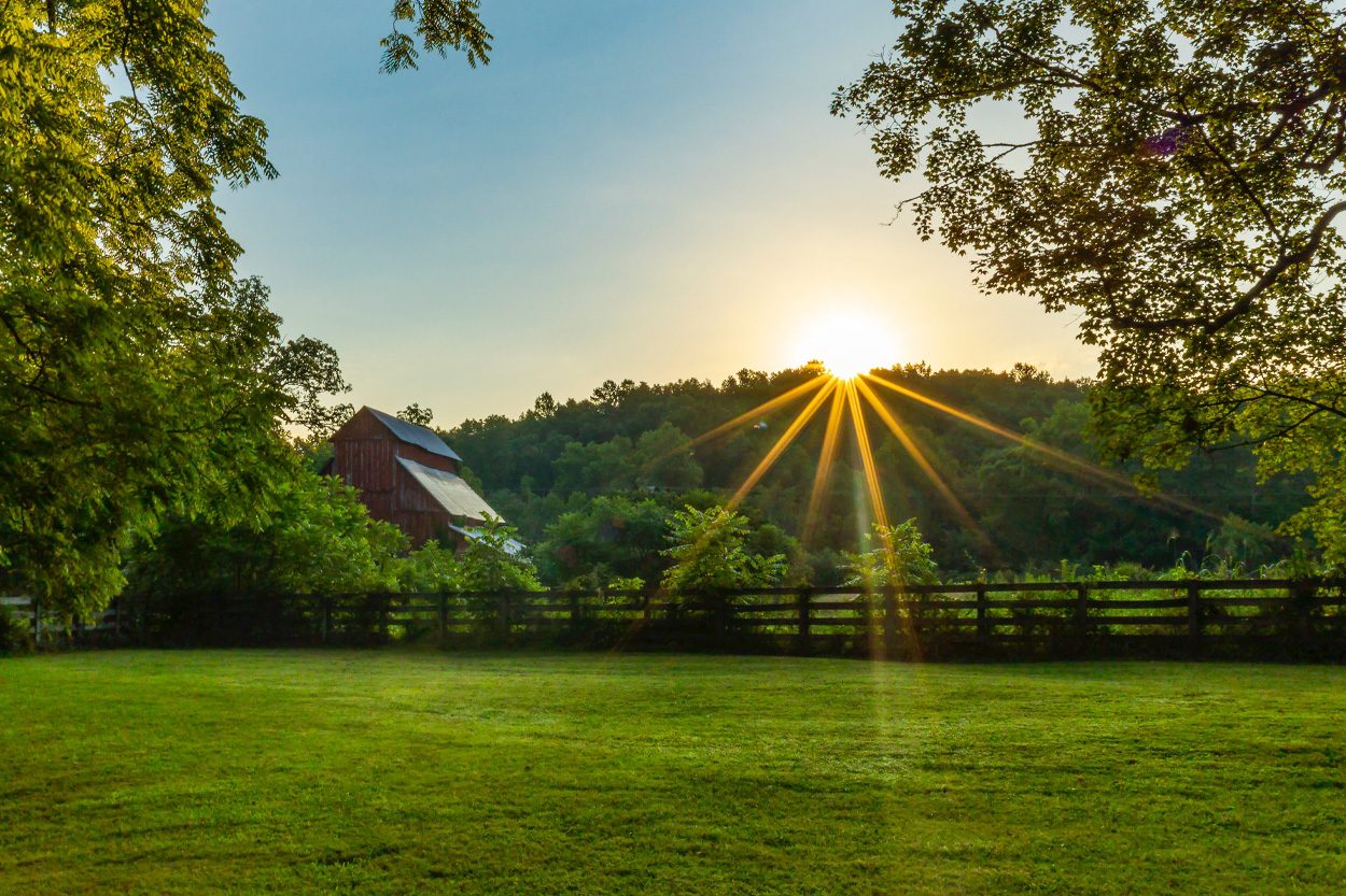 Sunset shining across a fenced green pasture near Rutledge in Grainger County, Tennessee